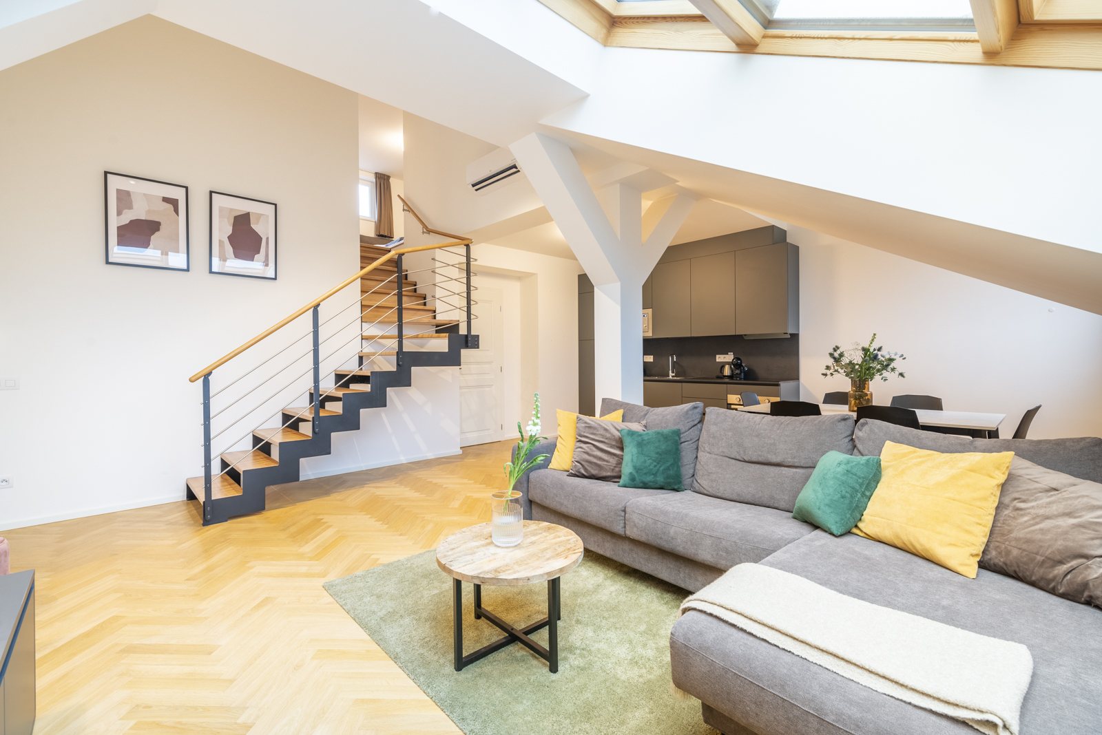 Obývací prostor dvoupodlažního apartmánu se schodištěm